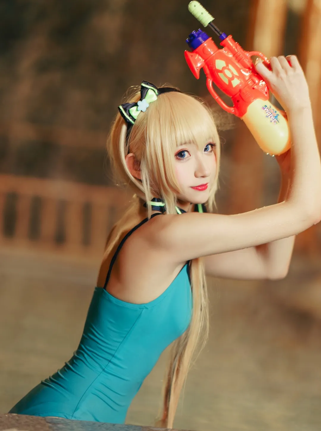 公开Cosplay摄影系列与武汉山百合作品归档 浅金长发角色身穿青绿色服装，双手举起红黄色水枪，在暖色木质室内水景中拍摄近景