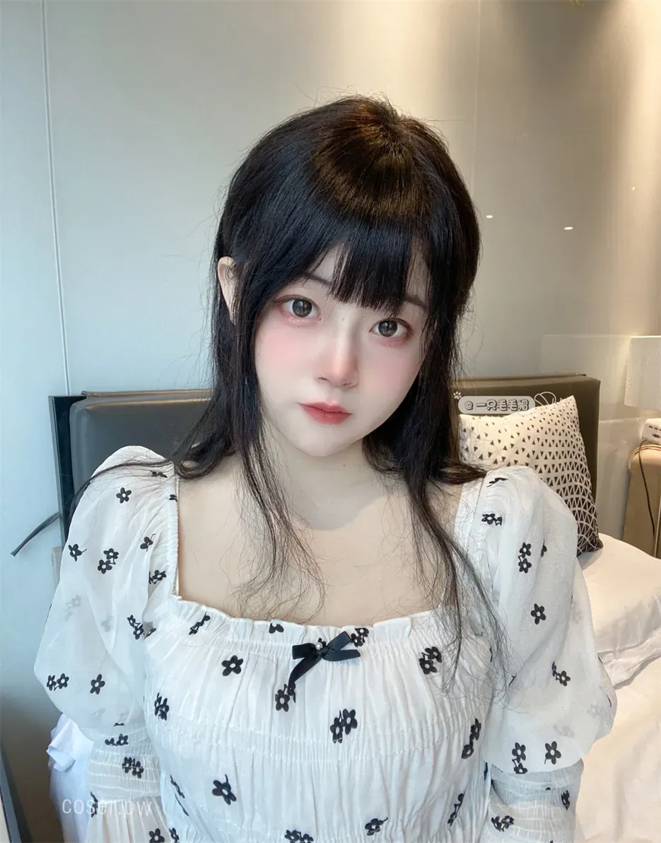 摄影线索阶段性整理 黑色长发人物穿白底黑色碎花裙，在床边室内环境中以柔和光线拍摄正面近景人像