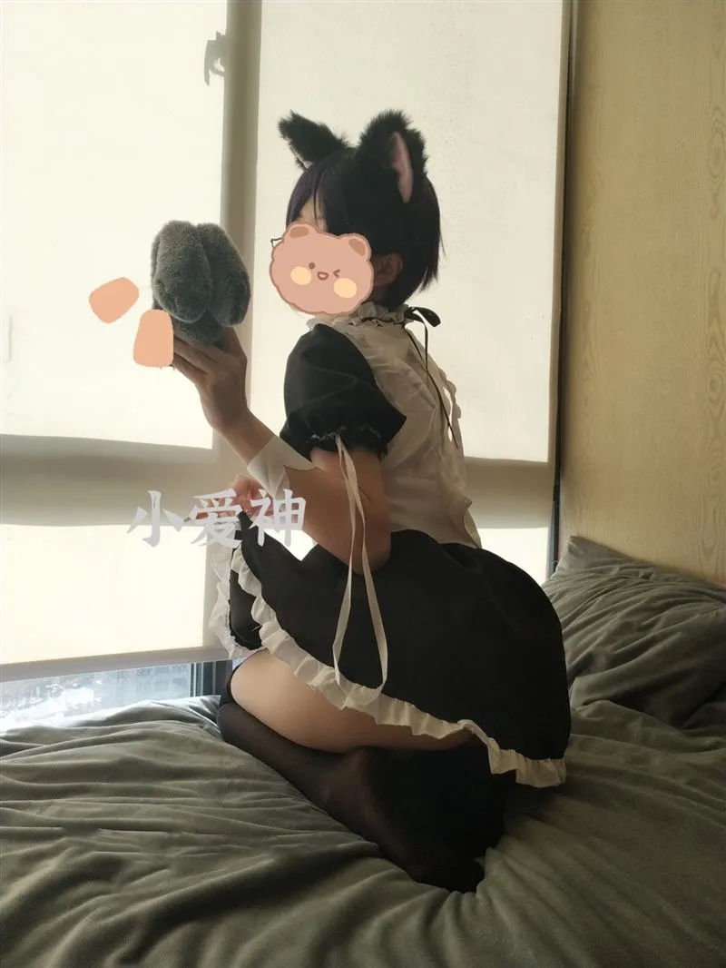 摄影系列归档 人物穿着黑白猫耳服装坐在床铺上的侧面照片