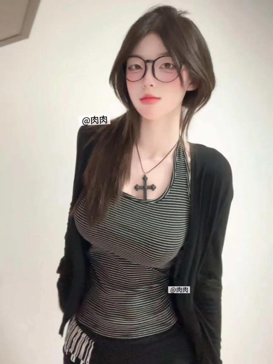 纯白背景前身穿黑绿细条纹吊带外搭黑开衫佩戴黑框眼镜与十字架项链