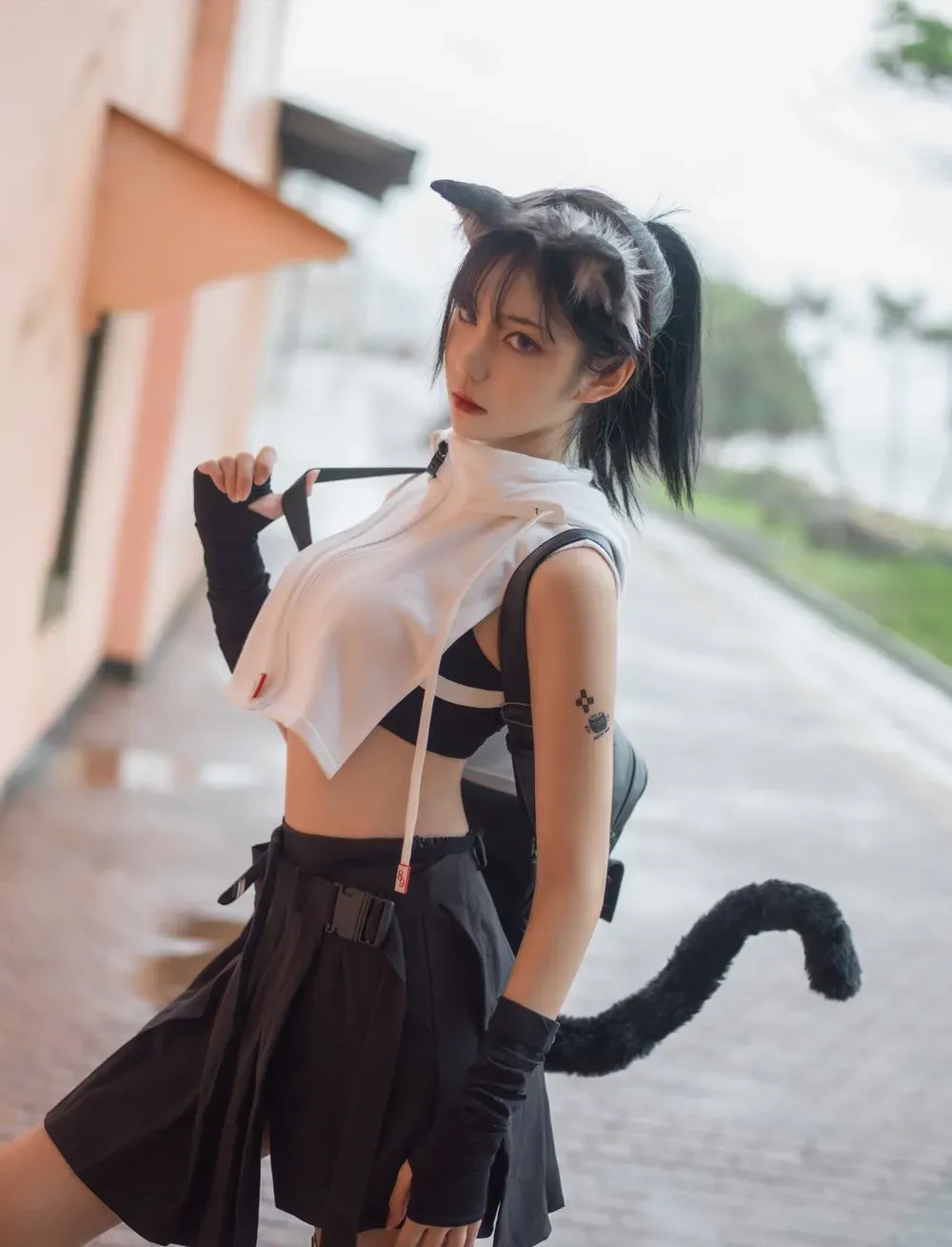抖音陈妮妮UNI头戴猫耳发饰身着黑白机能短上衣与百褶裙在户外街道侧身站立