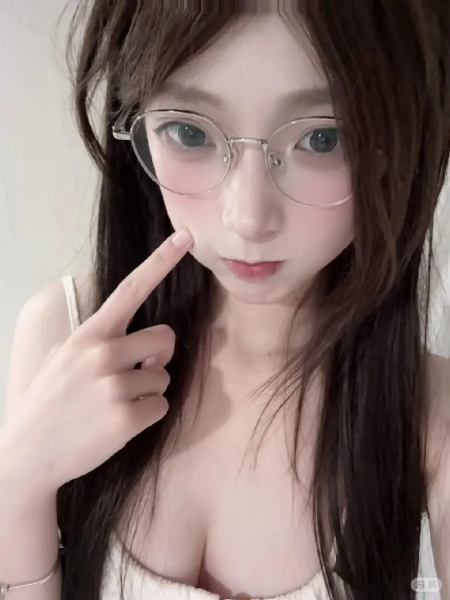 抖音小熊大王佩戴银色金属圆框眼镜并轻触面颊的室内近景特写自拍