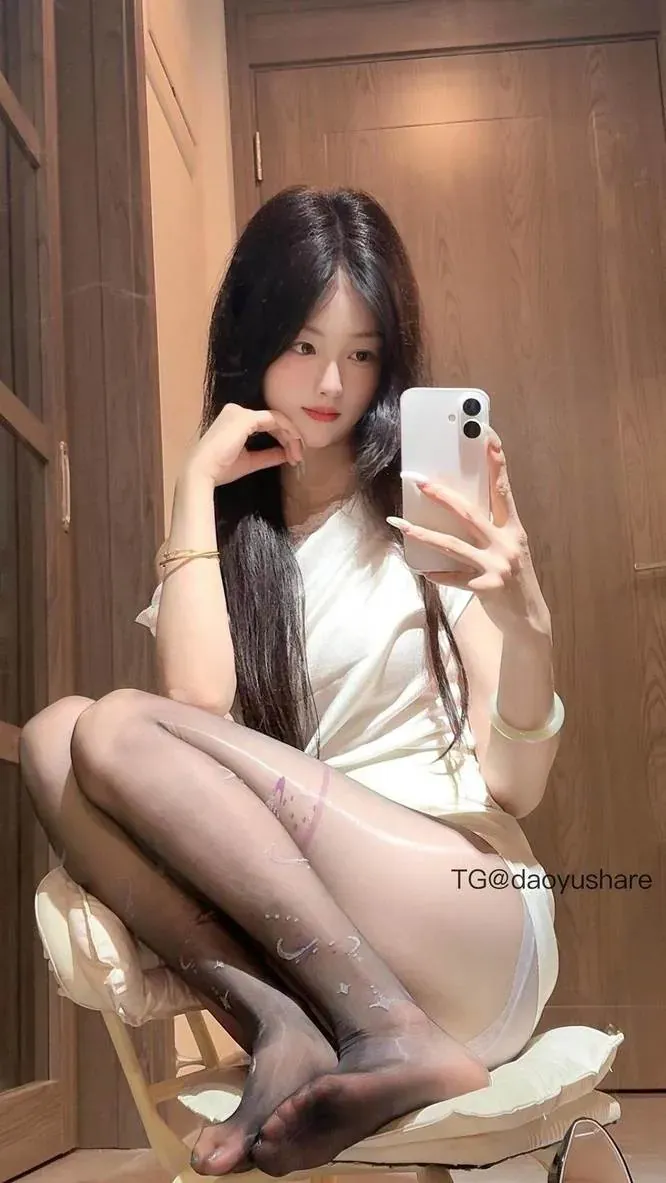 摄影系列作品归档 穿浅色上衣进行室内自拍,黑色长发垂落,手机位于画面右侧。